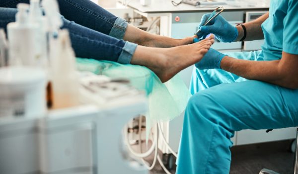 Professional doctor podiatrist doing medical pedicure procedure in the cabinet Prepare for Foot and Ankle Surgery